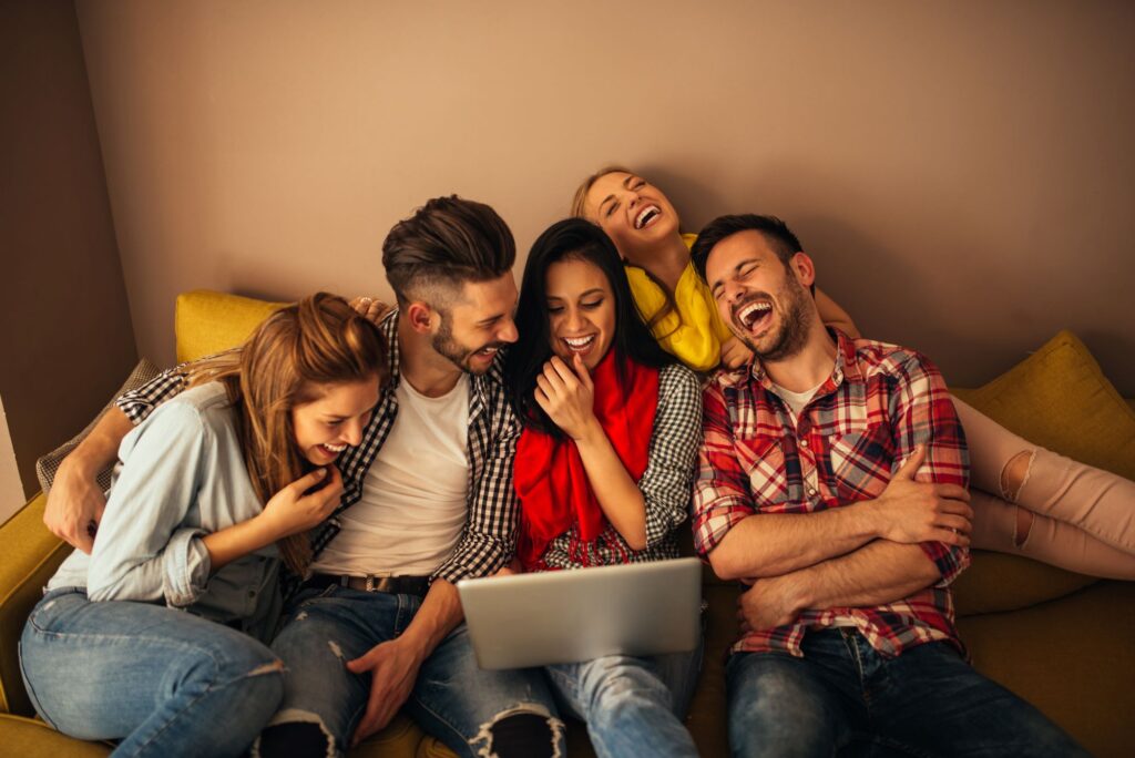 Group of friends watching a funny comedy series on a laptop