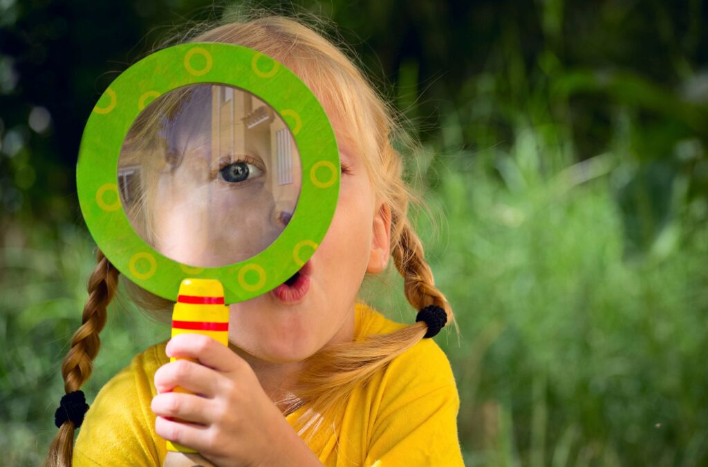Girl looking through magnifying glass