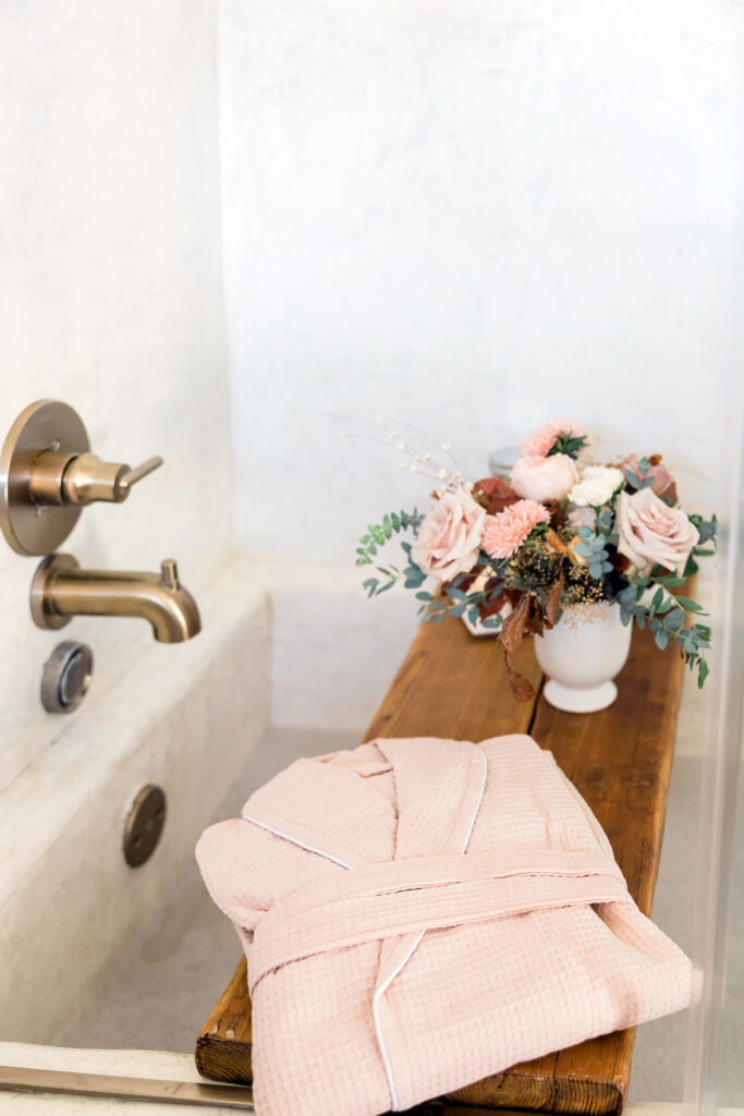 Pretty pink robe and flowers by a bath